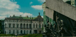 Pomnik Powstania Warszawskiego na tle historycznego budynku w Warszawie