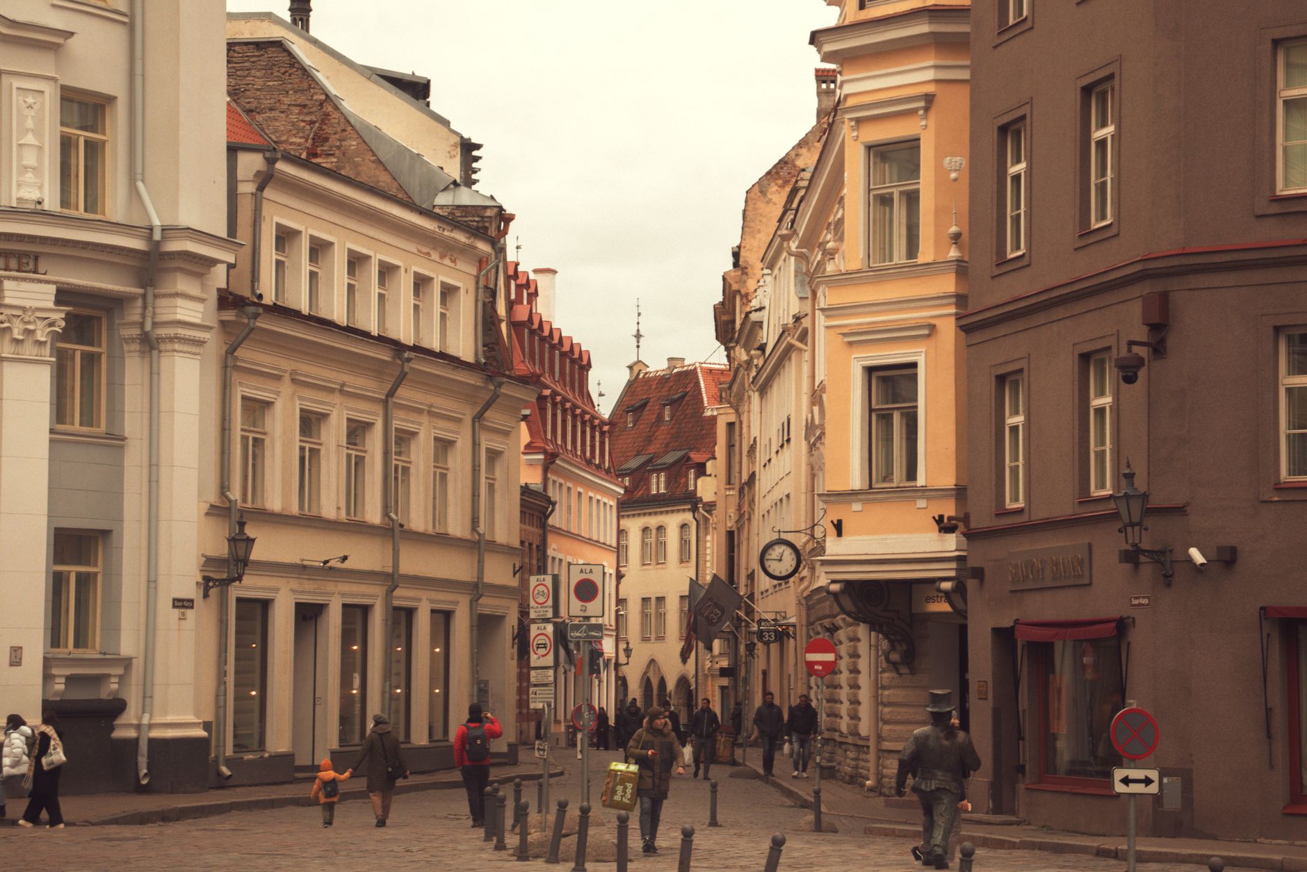 Przechodnie na jesiennej ulicy w zabytkowym centrum Tallinna