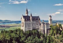 Zamek Neuschwanstein na wzgórzu wśród gór i lasów Bawarii