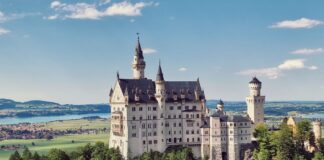 Zamek Neuschwanstein na wzgórzu wśród gór i lasów Bawarii