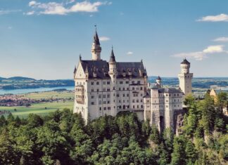 Zamek Neuschwanstein na wzgórzu wśród gór i lasów Bawarii