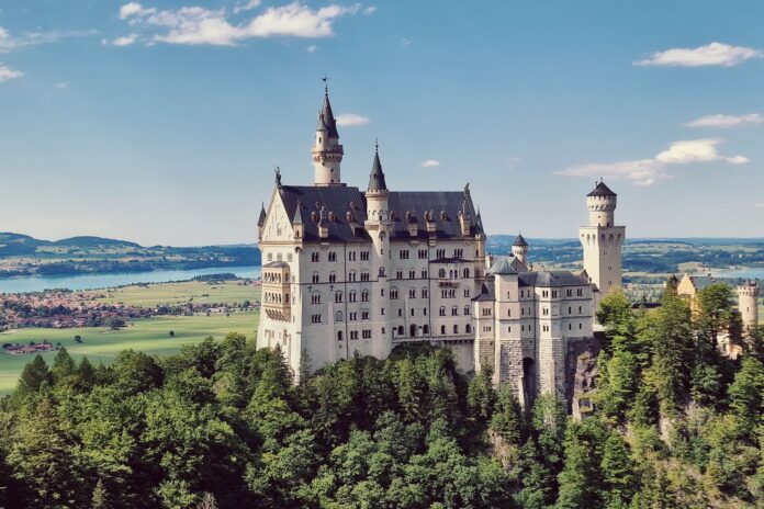Zamek Neuschwanstein na wzgórzu wśród gór i lasów Bawarii Zamek Neuschwanstein na wzgórzu wśród gór i lasów Bawarii