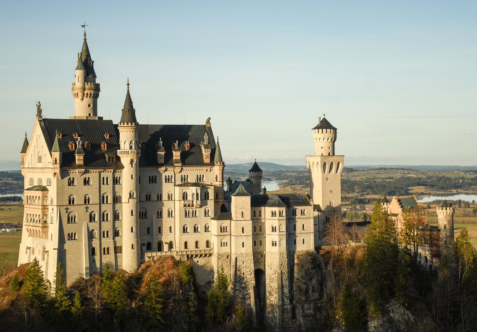 Zamek Neuschwanstein o zachodzie słońca na tle błękitnego nieba