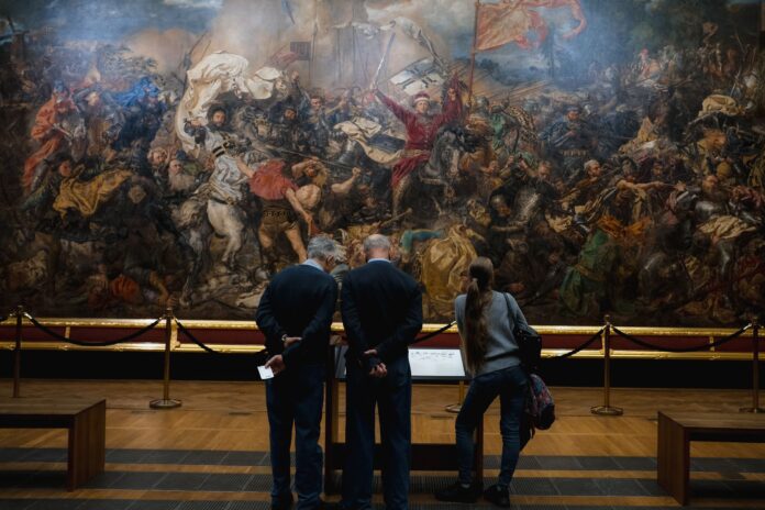 Zwiedzający oglądają wielkie malowidło historycznej bitwy w muzeum Zwiedzający oglądają wielkie malowidło historycznej bitwy w muzeum