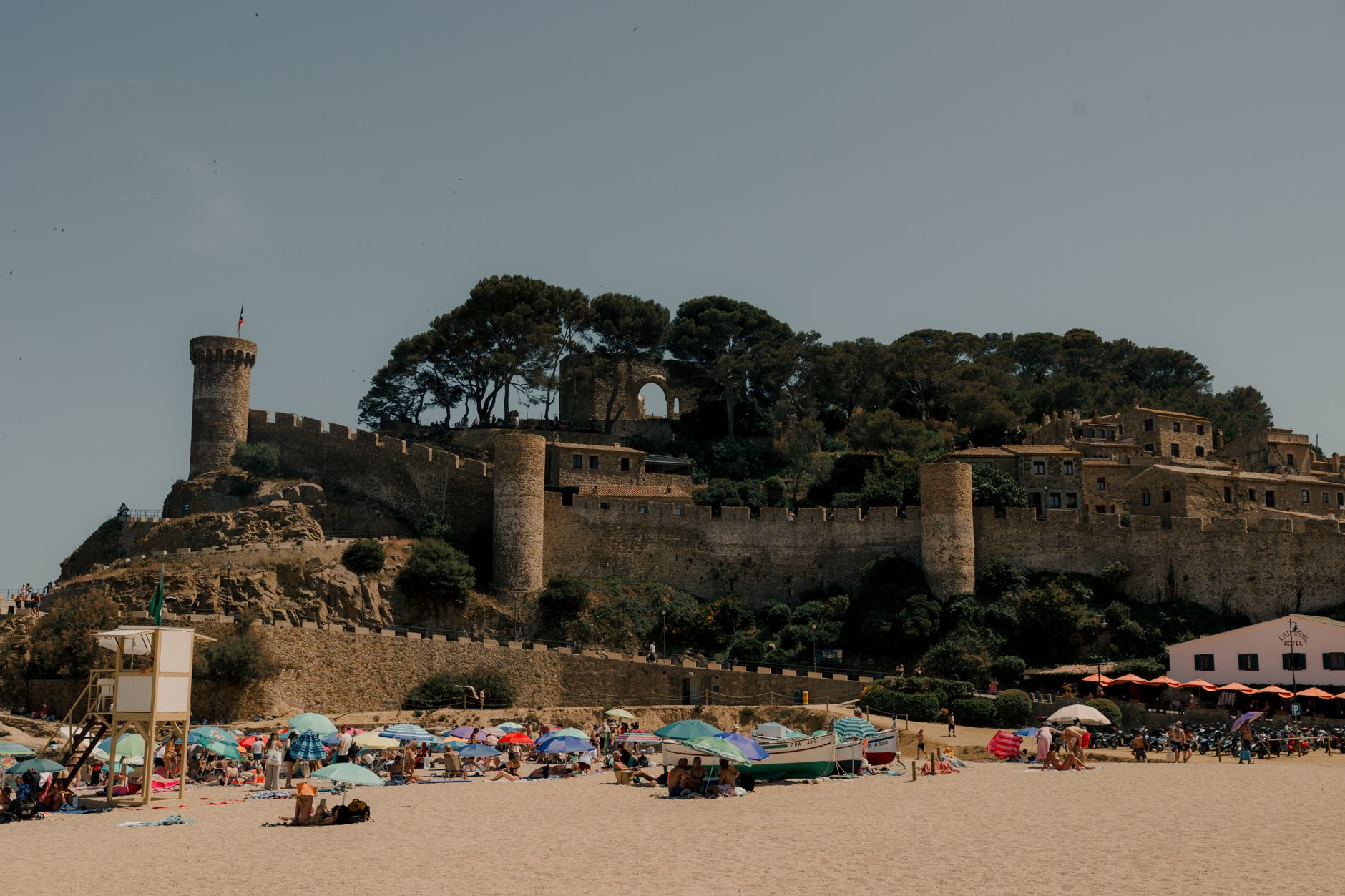 Zamek w Tossa de Mar przy piaszczystej plaży w słoneczny dzień