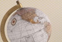 Kolonialne plany II RP – czy Polska naprawdę chciała zdobyć Madagaskar? Stylizowany globus z mapą świata i kompasem na teksturowanym tle